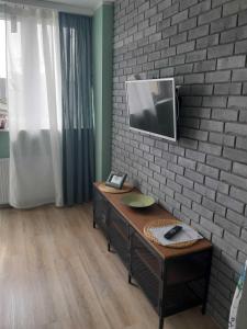 a room with a desk with a tv on a brick wall at Apartament ul Okopowa - Parking płatny in Kołobrzeg