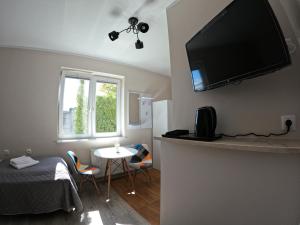 Habitación con cama y TV en la pared. en Noclegi na Wspólnej, en Słupca