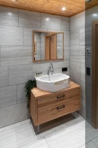 La salle de bains est pourvue d'un lavabo et d'un miroir. dans l'établissement Gletschersuite - KITZSTEINHORN, à Kaprun