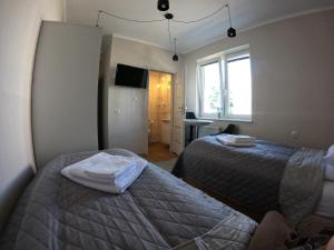 1 dormitorio con 2 camas y ventana en Noclegi na Wspólnej, en Słupca