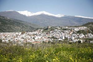 a city with snow covered mountains in the background at Las Terrazas del Jardin Nazari B41 in Vélez de Benaudalla