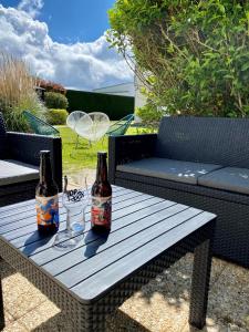 dos botellas de cerveza sentadas en una mesa de madera en Hôtel Campanile Orléans Nord - Saran, en Saran