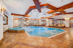 - une grande piscine intérieure dans une pièce dotée d'un plafond dans l'établissement Vila Miorita, à Poiana Brasov
