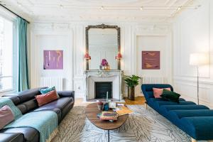 ein Wohnzimmer mit 2 blauen Sofas und einem Kamin in der Unterkunft Sweet Inn - Rue de Cerisoles in Paris