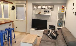 uma sala de estar com um sofá e uma televisão de ecrã plano em Apto Cimavilla. Wifi gratuito. VUT-827-AS em Gijón