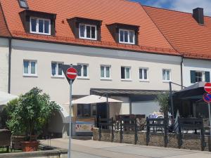 um sinal de rua em frente a um edifício branco em Pension HopfaHeisl em Wolnzach