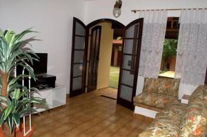 a living room with a couch and an open door at Chalé Massaguaçu in Caraguatatuba