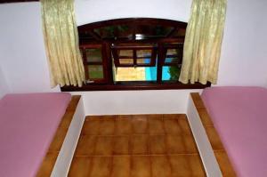 a room with two beds and a window at Chalé Massaguaçu in Caraguatatuba