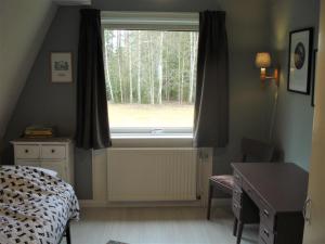 sypialnia z łóżkiem i oknem z drzewami w obiekcie Härlig Heden Vakantiehuis w mieście Råda