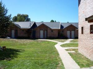 una fila de casas de ladrillo con un patio de hierba en Hosteria Tres Picos en Lago Puelo