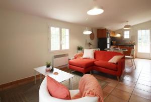 - un salon avec un canapé rouge et une table dans l'établissement Domaine du Flamand - Gîtes du Pin Sec côté OCEAN, à Naujac-sur-Mer