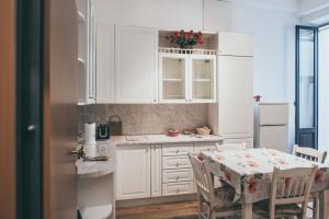 a kitchen with white cabinets and a table with chairs at Arte&Musica in Verona