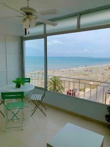 Sunny Beach Retreat في سانتا بولا: شرفة مع طاولة وكراسي وإطلالة على الشاطئ