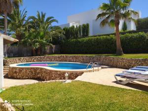uma piscina num quintal com palmeiras em Casa Birgid em Cala d´Or