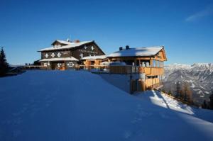 una casa en la cima de una montaña cubierta de nieve en Krummholzhütte, en Haus im Ennstal
