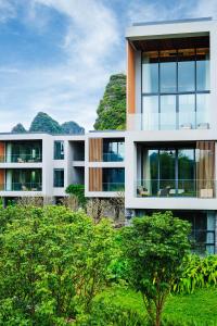 an image of a building with mountains in the background at LUX* Chongzuo, Guangxi Resort & Villas in Daxin