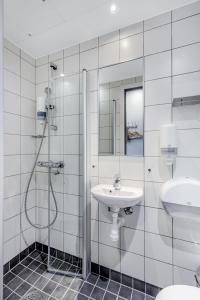 a white bathroom with a sink and a shower at Citybox Lite Kristiansand in Kristiansand