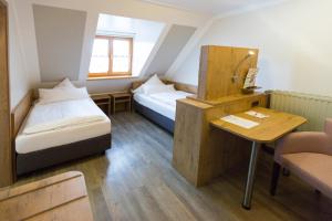 WeicheringにあるLandgasthof Vogelsang OHGのベッド2台とテーブルが備わる小さな客室です。