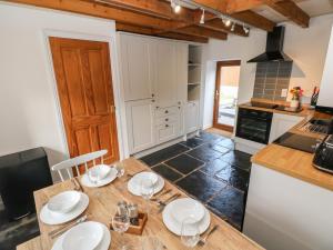 una cucina con tavolo in legno e piatti di Dalton Cottage a Kidwelly