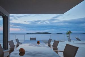 a dining room with a table and chairs on a balcony at Villa Roca in Vis