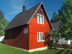 un fienile rosso con tetto nero di Guesthouse Durmitor Magic a Žabljak