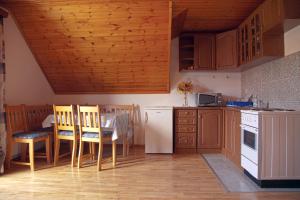 a kitchen with wooden cabinets and a table and chairs at Guesthouse Zafran in Smoljanac