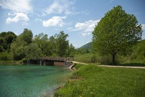 a bridge over a river next to a field at Guesthouse Zafran in Smoljanac