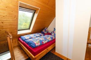 Bett in einem kleinen Zimmer mit Fenster in der Unterkunft Ferienwohnung auf Rügen für 3 Erwachsene und 1 Kind in Schaprode
