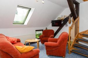 ein Wohnzimmer mit 2 Stühlen und einer Treppe in der Unterkunft 3-Raum FeWo für 5 Personen + 1 Aufbettung auf Rügen in Schaprode
