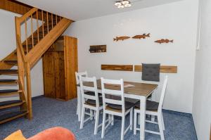 ein Esszimmer mit einem Tisch, Stühlen und einer Treppe in der Unterkunft 3-Raum FeWo für 5 Personen + 1 Aufbettung auf Rügen in Schaprode