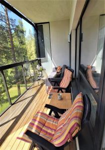 a screened in porch with chairs and a table at Sunny Beach Apartment in Narva-Jõesuu