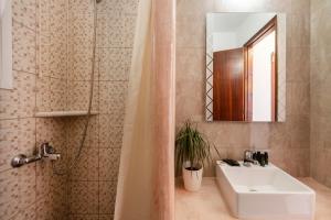 łazienka z umywalką i prysznicem z lustrem w obiekcie Stella Hotel w mieście Parikia