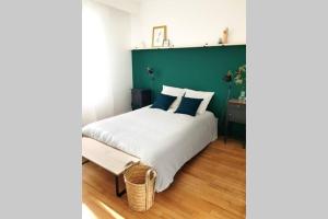 a bedroom with a bed with a green wall at Le Petit Nicolas in Les Andelys