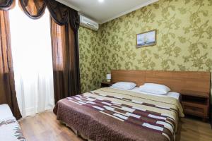 アドレルにあるArkadia Guest Houseの緑の壁紙のベッドルーム1室(ベッド1台付)