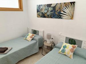 a room with two beds and a painting on the wall at Sunny Beach Retreat in Santa Pola