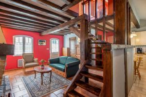 a living room with a staircase and red walls at Maison charmante à Bangor avec jardin et cheminée in Bangor