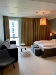 pokój hotelowy z łóżkiem i kanapą w obiekcie Scandic Kristiansand Bystranda w mieście Kristiansand