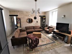 a living room with couches and a flat screen tv at L'instant Présent in Pacy-sur-Armançon