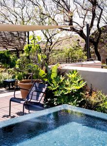 a swimming pool with a chair and some plants at Hotel Neri – Relais & Chateaux in Barcelona