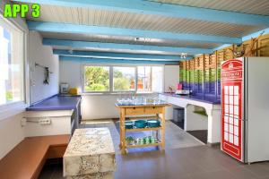 eine Küche mit einem Tisch und einem roten Kühlschrank in der Unterkunft Apartments Dreamland in Baška