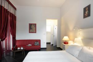 1 dormitorio con 1 cama y 1 sofá rojo en Maria Vittoria Charming Rooms and Apartments, en Brindisi