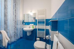 bagno blu con servizi igienici e lavandino di Maria Vittoria Charming Rooms and Apartments a Brindisi