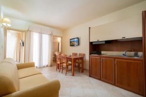 a living room with a kitchen and a dining room table at Hotel Regina Elena in Olbia