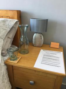 eine Lampe auf einem Nachttisch neben einem Bett in der Unterkunft The Den at Pinchbeck in Spalding