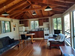a living room with a couch and a table at Orana"Welcome" Cabin in The Tops in Bandon Grove