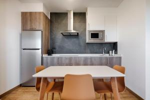 cocina con mesa, sillas y nevera en TH Apartments by Como en Casa, en A Coruña