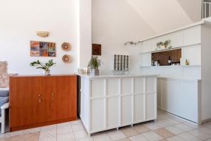 a kitchen with white cabinets and a counter at Stella Hotel in Parikia