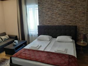 a bedroom with a large bed and a brick wall at Shara Talyan 8/2 Guest House in Yerevan