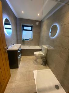een badkamer met een toilet, een bad en een wastafel bij Ty Melyn, Newgale in Newgale