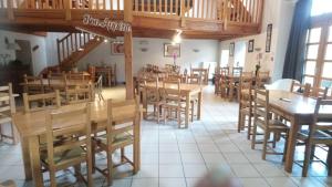 une salle à manger avec des tables et des chaises en bois dans l'établissement L'auberge De La Source, à La Valla